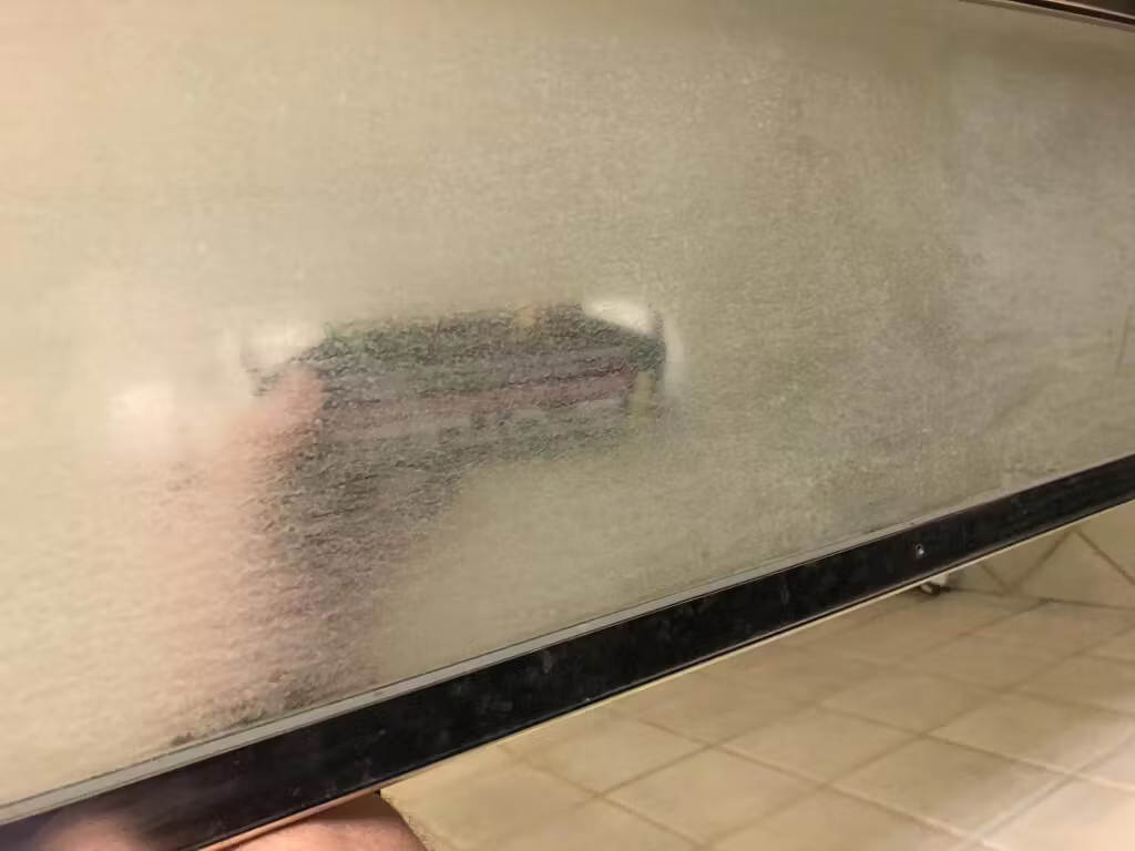 Glass shower panel before: frosted with mineral haze