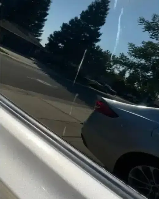 Car side window after: clear glass reflecting trees and sky