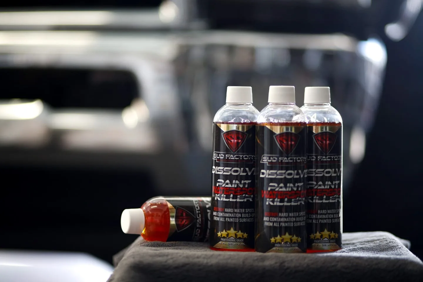 Sud Factory Spotless X2, Dissolve X2 and SFX1 bottles lined up on a car