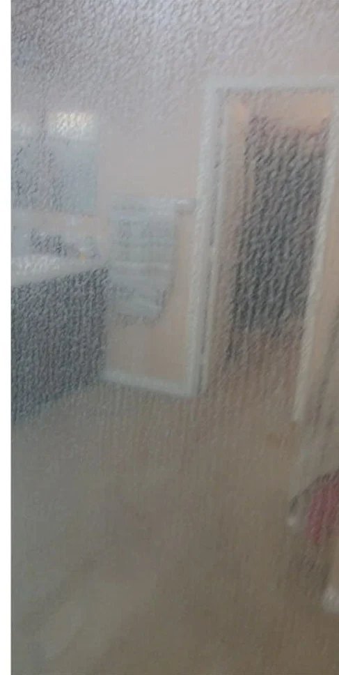 Shower glass door clouded with hard water haze